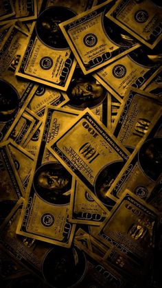 a pile of money sitting on top of a black table covered in gold foil dollar bills