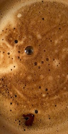 a pan filled with brown liquid on top of a stove