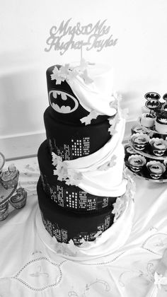 a black and white photo of a batman themed wedding cake