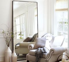 a living room filled with furniture and a large mirror