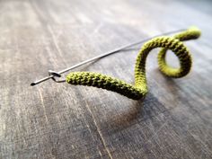 a pair of knitting needles sitting on top of a wooden table