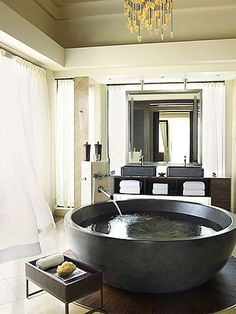 a large black bath tub sitting next to a bathroom sink