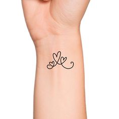 a woman's wrist tattoo with two hearts on it