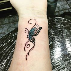 a small butterfly tattoo on the wrist