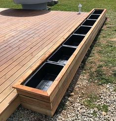 a boat sitting on top of a wooden deck next to a grass covered park area