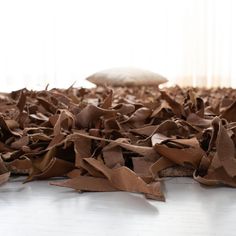 a pile of brown paper sitting on top of a white floor next to a window