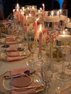 a table set with candles, plates and napkins for a formal dinner or party