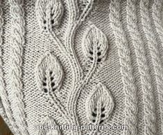 a close up of a knitted sweater with leaves on the front and back side