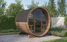 a wooden barrel like structure sitting in the middle of a garden