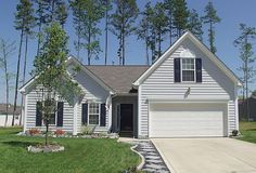 a white house with black shutters and trees in the background