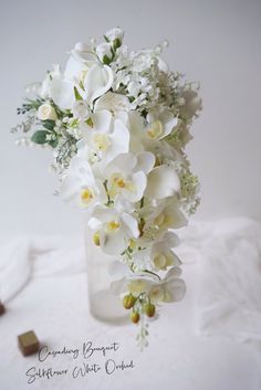 a bouquet of white flowers in a glass vase