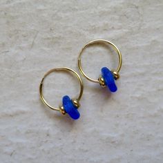 Seaglass Hoop Earrings~ These cute small endless hoops have blue seaglass and gold beads, great gift for the beach lover. Hoops 16mm. *This listing is for the earrings in the first photo ready to ship **video shows 20 and 24mm. hoops Shop~ http://www.etsy.com/shop/HanaMauiCreations?ref=pr_shop_more International buyers please read our shipping policies before ordering~ POLICIES~ https://www.etsy.com/shop/HanaMauiCreations/policy?ref=shopinfo_policies_leftnav Adjustable Blue Hoop Earrings For Beach, Blue Hoop Jewelry For The Beach, Blue Small Hoop Jewelry For The Beach, Blue Small Hoop Jewelry For Beach, Beach Jewelry With Tiny Beads, Blue Small Hoop Earrings With Tiny Beads, Adjustable Small Hoop Jewelry For Beach, Glass Hoop Earrings For Gift, Glass Hoop Earrings As Gift