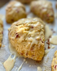 biscuits with icing and cranberries are on a baking sheet, ready to be eaten