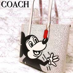 an image of a handbag with cartoon character on it and the words coach written in red