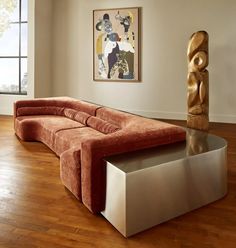 a couch sitting on top of a wooden floor in a living room next to a window