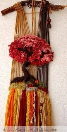 a wall hanging made out of yarn with a tree on the top and branches above it