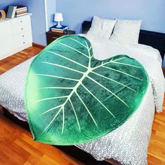 a bed with a green leaf shaped comforter on it