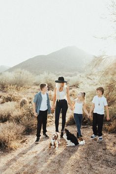 three kids and their dog walking in the desert