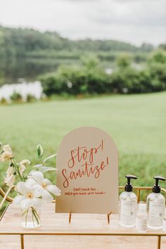 a sign that says stop sanitizing on it next to some soap bottles and flowers