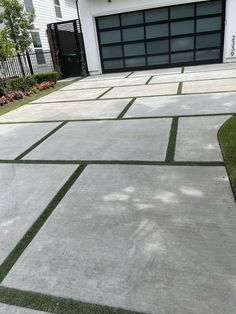 a driveway with grass in front of it and a garage door on the other side