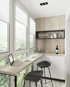 two stools sit in front of a kitchen counter with a laptop on it, next to a window