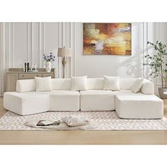 a white couch sitting on top of a wooden floor next to a rug and table