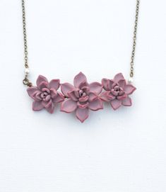 "Featuring Trio Pale Mauve Succulent Centered Necklace, Pale pink Purple Succulent Necklace, Succulent wedding Jewelry, Succulent Jewelry All Succulents Jewelry available at below link: https://www.etsy.com/shop/Diaszabo?ref=listing-shop2-all-items-count&section_id=20503443 Material and size : Hand wired Trio Succulents. Size approximately 25-26mm and 30mm across. Cream Swarovski pearls. Antiqued brass chain ( pictured). Available in silver plated, gold plated. The entire length available in Pink Necklace With Flower Charm For Wedding, Pink Wedding Necklace With Flower Charm, Pink Flower Charm Jewelry For Bridesmaid Gift, Adjustable Pink Flower Necklace For Wedding, Pink Flower Charm Necklace For Wedding, Succulent Necklace, Succulent Jewelry, Purple Succulents, Succulent Wedding