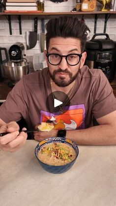 a man sitting at a table with a bowl of soup in front of him