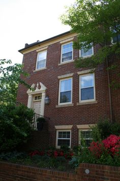 a brick building with many windows and flowers