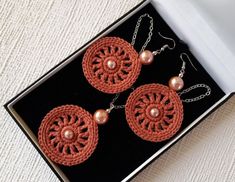 a pair of earrings in a box on a table