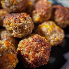 some meatballs are sitting on a black plate and ready to be eaten by someone