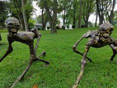 two metal skeletons standing in the grass