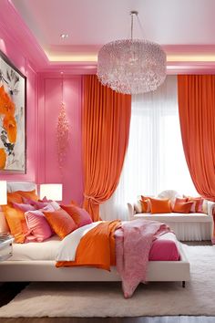 a bedroom decorated in pink and orange with chandelier hanging from the ceiling above the bed