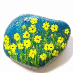 a painted rock with yellow flowers on it