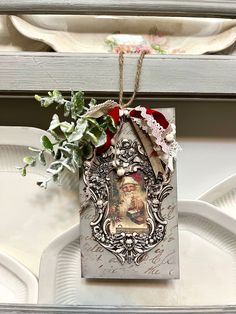 a christmas ornament hanging from the side of a shelf with flowers on it