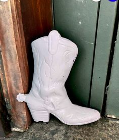 a pair of white cowboy boots sitting next to a door