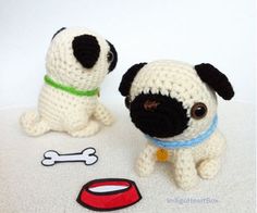 two crocheted stuffed dogs sitting next to each other on a white surface with a dog bone