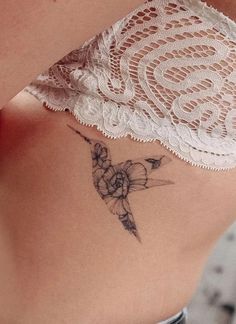 a woman's stomach with a tattoo on her side and a lace garter