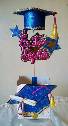 a graduation cake topper in the shape of a mortar cap and tassel with congratulations written on it