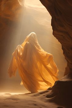 a woman in a yellow dress is walking through a cave with light coming from the ceiling