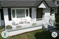 a white house with black shutters and stairs