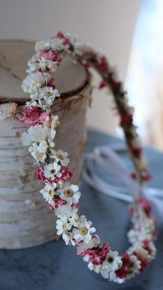 a white and pink flower headband sitting on top of a table