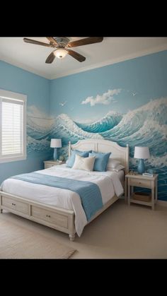 a bedroom decorated in blue and white with waves painted on the wall behind the bed