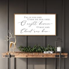 a wooden table topped with a sign next to a vase filled with flowers and greenery