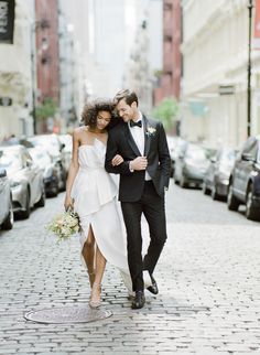 a bride and groom walking down the street