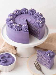 a purple cake with one slice missing from it