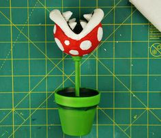 a potted plant with a red and white polka dot mushroom on it's head