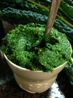 a white bowl filled with green food on top of a table