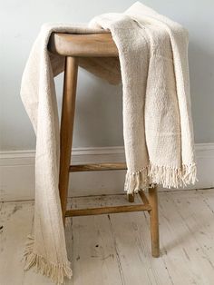 a wooden stool with a white blanket draped over it