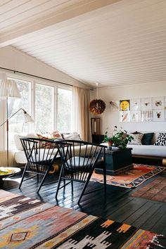 a living room filled with lots of furniture and decor on top of a hard wood floor